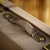 Nærbillede af slidstærk, genanvendt polyester taskestrop med sikkert gult spænde.