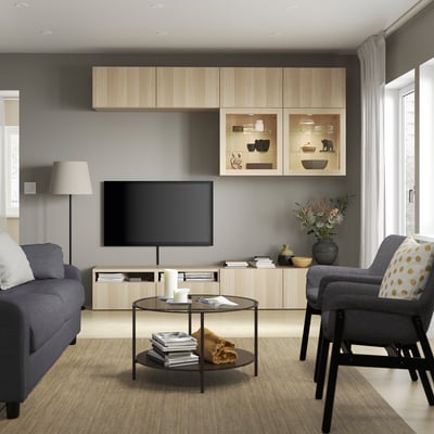 Moderne stue med egetræsskab, grå sofa, sofabord, tv, stole.