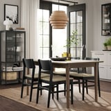 Moderne spiseplads med SKANSNÄS udtrækkeligt bord og stole, naturligt træ og sort, minimalistisk design.