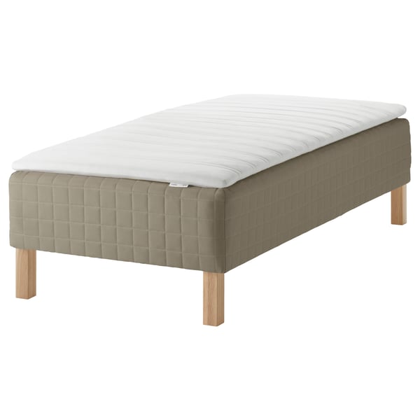 Moderne seng med hvid madras, beige polstret bund, lyse træben.