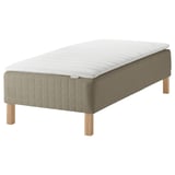Moderne seng med hvid madras, beige polstret bund, lyse træben.