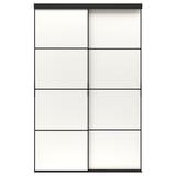 En SKYTTA skydedør i sort med matterede glaspaneler. Det moderne design en anodiseret aluminiumsramme og fyrretræsstøtteskinner.
