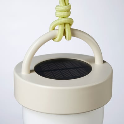Den solcelledrevne SOLVINDEN lygte er hvid, kugleformet, med et beige håndtag og et limegrønt reb. Det er moderne og miljøvenligt.