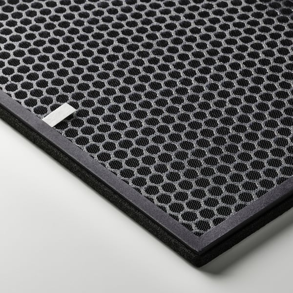 Sort sekskantet mønstret luftfilter med et rektangulært metalmærke, indrammet af mørk plast. Design af høj kvalitet, effektiv til fjernelse af lugt.