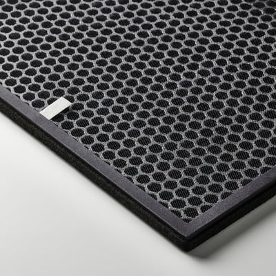 Sort sekskantet mønstret luftfilter med et rektangulært metalmærke, indrammet af mørk plast. Design af høj kvalitet, effektiv til fjernelse af lugt.