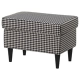 En STRANDMON skammel, sort og hvid houndstooth mønster, firkantet form, med mørkt træ tilspidsede ben.