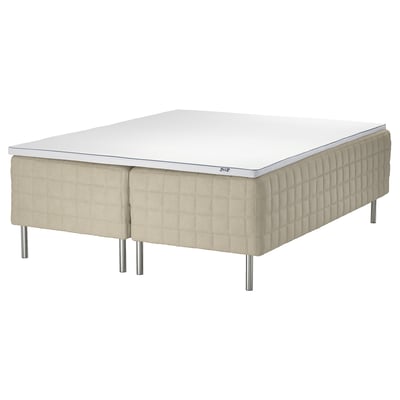 Moderne beige seng med metalben.