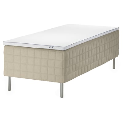 En IKEA STUVLAND cremefarvet seng med en hvid madras med quiltet mønster og metalliske ben.