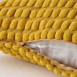 Gult pudebetræk med blødt, tekstureret mønster og lynlåsåbning. Fremstillet af genanvendt polyester.