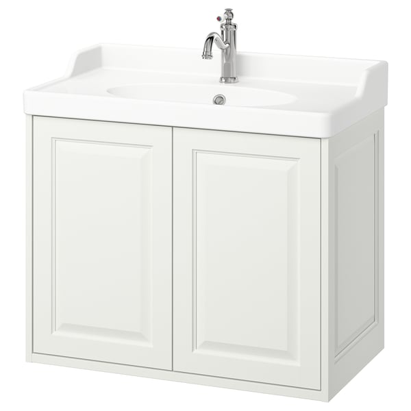 Dette billede viser et TÄNNFORSEN hvidt badeværelsesskab med en marmorvask og kromarmatur. Den har to låger og et klassisk design.