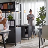 To kvinder på moderne kontor med TROTTEN skriveborde og stole.