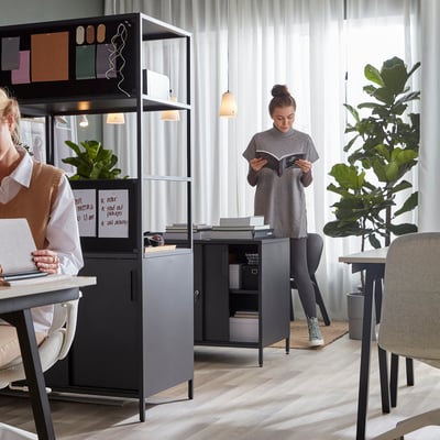 To kvinder på moderne kontor med TROTTEN skriveborde og stole.