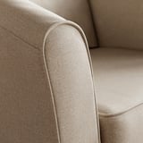 Close-up af en beige polstret stolarmlæn, der fremviser glat, højkvalitets stof og rene syninger.