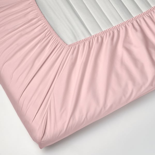 Et lyserødt sengeskørt med elastikkant, designet til at passe til madrasser op til 8 cm tykke.