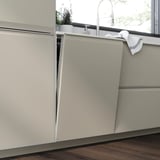 Moderne køkken med beige skabe, trægulv.
