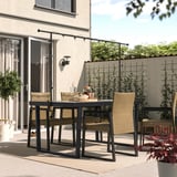 Moderne terrassesæt med rektangulært sort metalbord, fire kurvestole og hængende lyskæder, ideel til udendørs spisning eller afslapning.