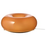 En VARMBLIXT orange glaslampe med en donutform, med et varmt skær og et slankt design.
