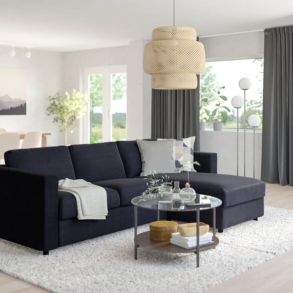Moderne stue med VIMLE sofa, sofabord i glas og stort vindue.