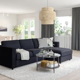 Moderne stue med VIMLE sofa, sofabord i glas og stort vindue.