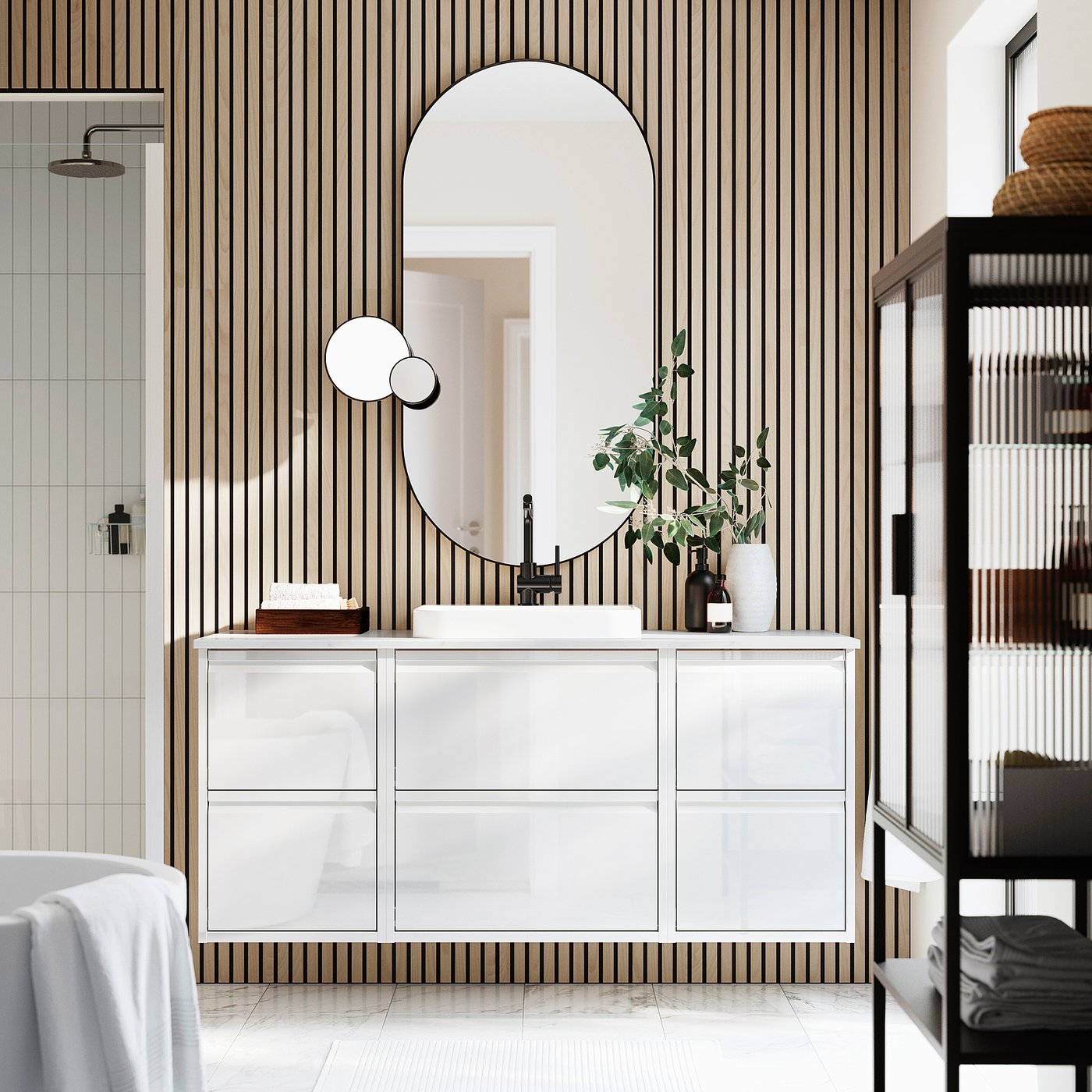 Modern bathroom with ÄNGSJÖN white vanity, large round mirror, and striped wall.