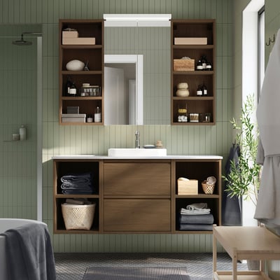 Modern bathroom with green walls, oak vanity, sink, storage, mirror, plant.