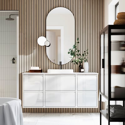Modern white vanity, striped bathroom, large mirror, drawers, decorative items, black towel shelf.