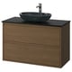Modern bathroom vanity with walnut wood, black countertop, and glass sink.