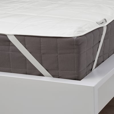 A quilted mattress protector shown, featuring elastic straps on corners, ensuring it stays in place on a bed.