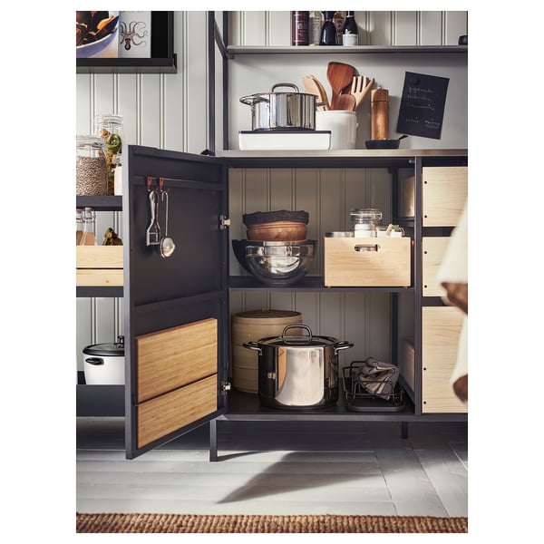 Open kitchen cabinet with pots, pans, and tools from ÄSPINGE series.