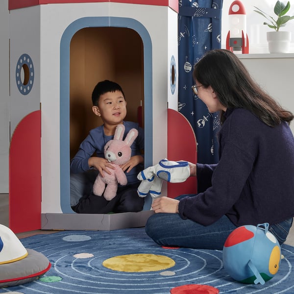 Woman & child play in AFTONSPARV spaceship with toys