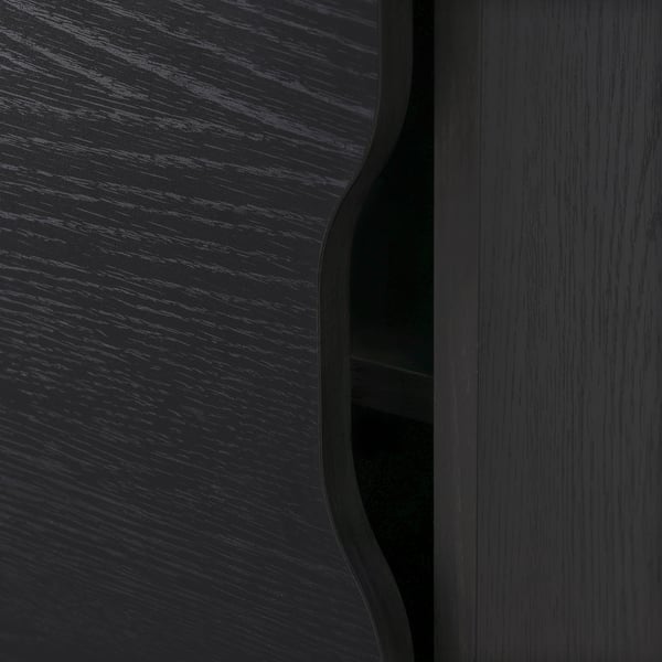 Dark wooden furniture close-up, showcasing smooth, polished surface and rounded edge.