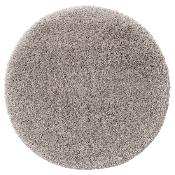 Round, grey, plush bath mat with soft microfiber texture, recycled polyester pile, and latex backing, ideal for comfort and absorption.
