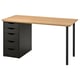 An ANFALLARE desk with a light wooden top and black drawers. It has a sleek, modern design suitable for small spaces.