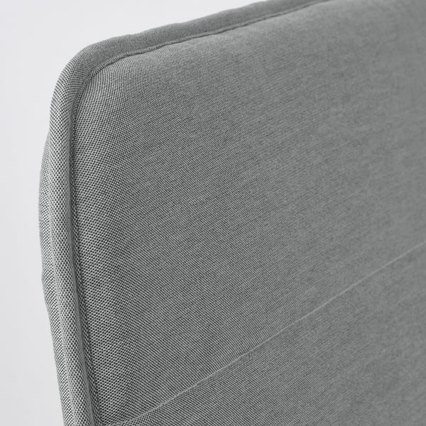 Close-up of modern, upholstered chair in grey fabric, showcasing smooth, clean lines and quality stitching.