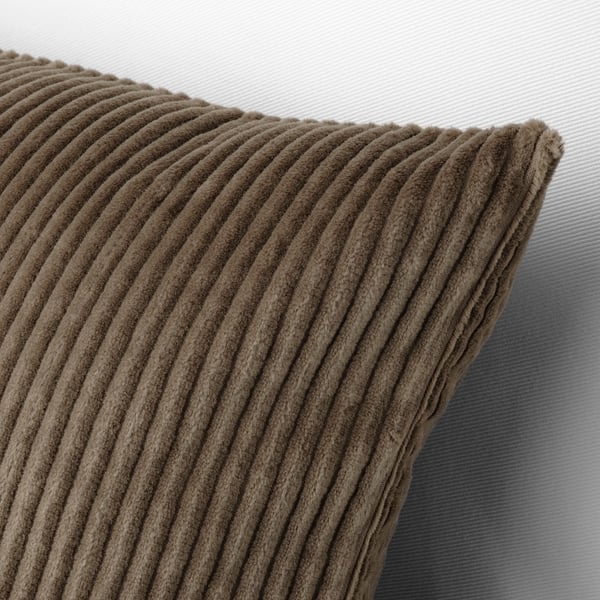 Close-up of textured brown corduroy throw pillow. Horizontally ribbed pattern, soft and inviting, sits on light-colored background.
