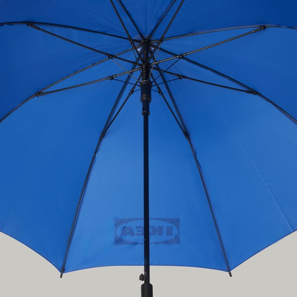 Bright blue umbrella open, showcasing sturdy black frame and handle.