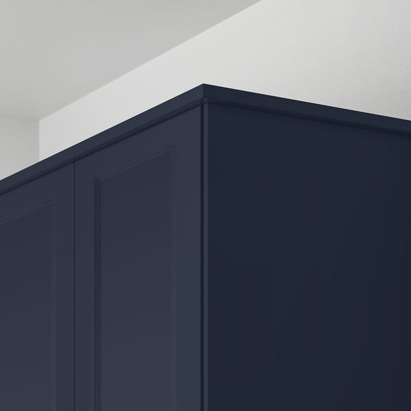 Dark blue kitchen cabinet trim, showing top and side panels, highlighting its decorative and functional use to hide lighting units and cords.