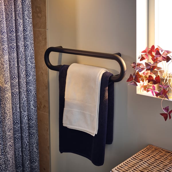 Dark grey towel rail hangs two towels, sleek rounded design.