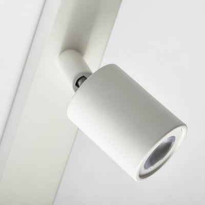 Close-up of modern, minimalist wall-mounted spot light, cylinder-shaped with adjustable angle.