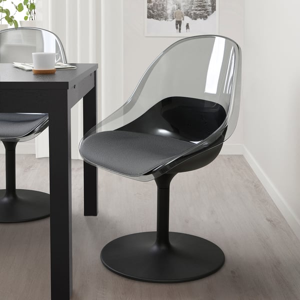 The BALTSAR chair in black a clear, curved shell with grey fabric seating. It swivels and complements modern spaces.