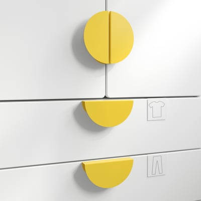 Bright yellow circular and semi-circular knobs on white cabinet doors, enhancing grip and style.