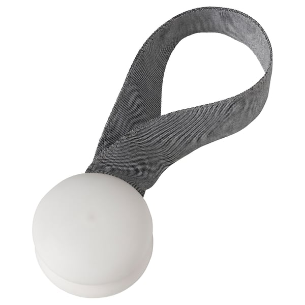 A grey fabric tie-back called BERGKLEMATIS with white magnetic ends for holding back curtains.