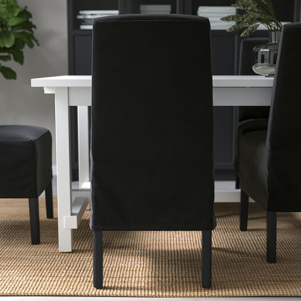 Black dining chair with wooden legs, cushioned for comfort and lumbar support. Removable, washable cover.
