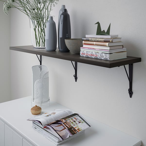 Wall-mounted shelf displays books, vases, and decor. Securely fixed, it uses wall space efficiently.