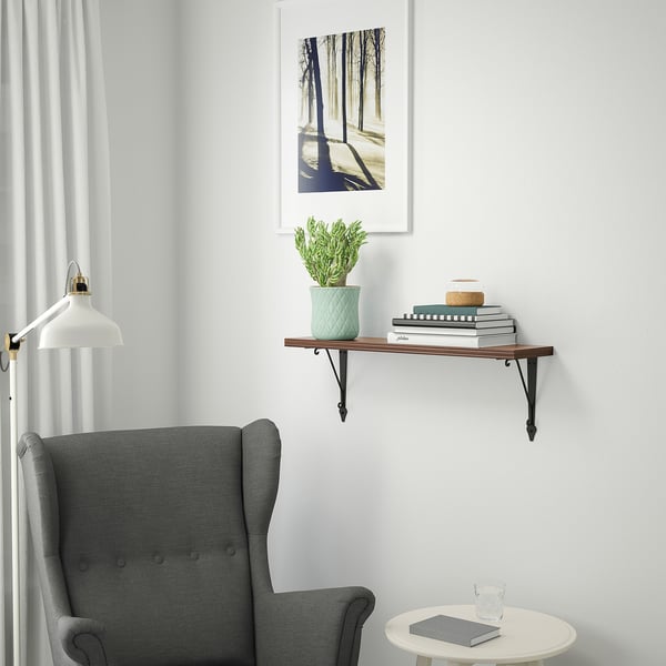Cosy reading nook with BERGSHULT shelf, books, plant, and chair.