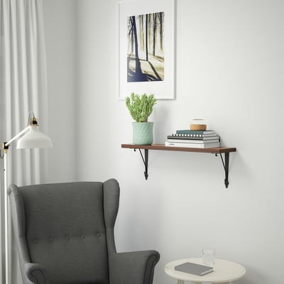 Cosy reading nook with BERGSHULT shelf, books, plant, and chair.