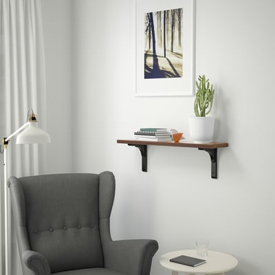 Grey nook: BERGSHULT shelf with books & plant, grey armchair, side table, forest print.