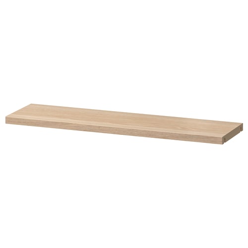 An ikea BESTÅ adjustable wooden shelf. It is rectangular, light brown, and made of particleboard with plastic edging.