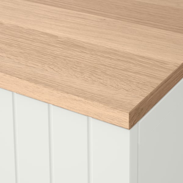 A sleek, well-crafted wooden tabletop with a smooth, light finish, supported by white vertical panels.