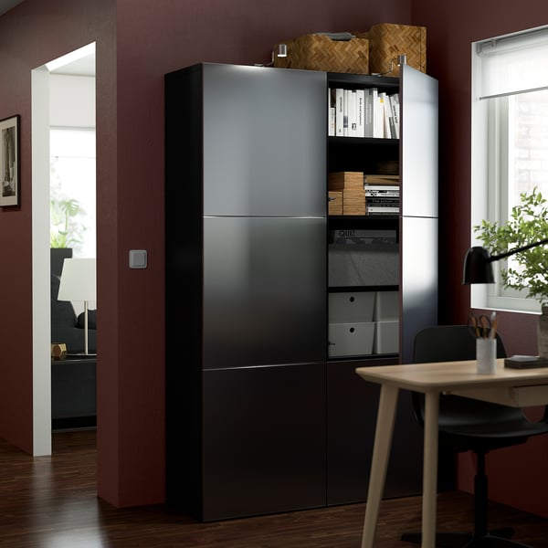Modern office setup with tall black BESTÅ storage unit, featuring adjustable shelves and soft-close doors.